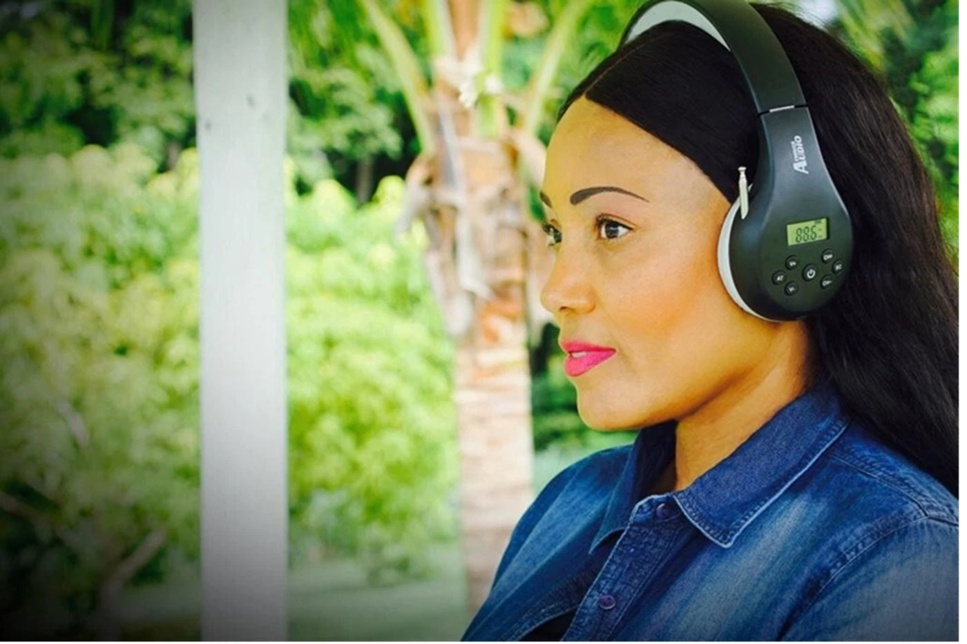 Woman wearing black and gray Things Audio FM radio over-ear headphones outdoors