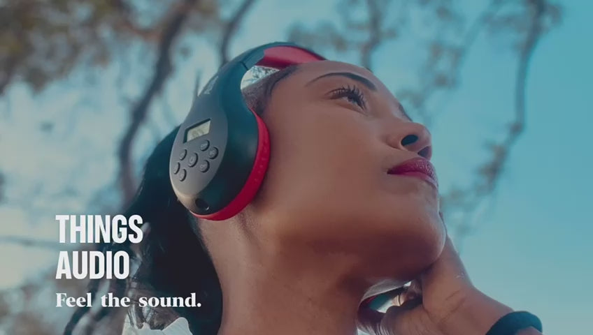 Woman wearing Things Audio over-ear headphones outdoors