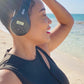 Person wearing black Things Audio over-ear FM radio headphones on the beach side view