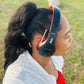 Person wearing black and red Things Audio FM radio over-ear headphones outdoors